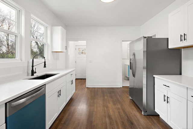 kitchen with dishwashing machine, dark wood-style flooring, light countertops, a sink, and stainless steel fridge with ice dispenser