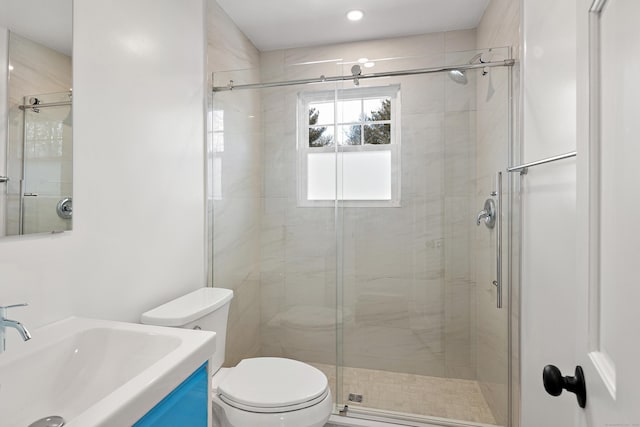 bathroom with toilet, a stall shower, and vanity