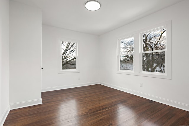 empty room with baseboards and dark wood-style flooring