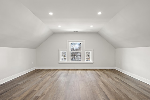 bonus room featuring lofted ceiling, baseboards, wood finished floors, and recessed lighting