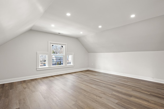 additional living space with lofted ceiling, recessed lighting, wood finished floors, and baseboards