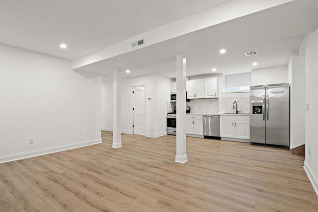 kitchen with stainless steel appliances, visible vents, white cabinetry, backsplash, and light wood finished floors