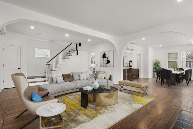 living area with stairs, arched walkways, and recessed lighting