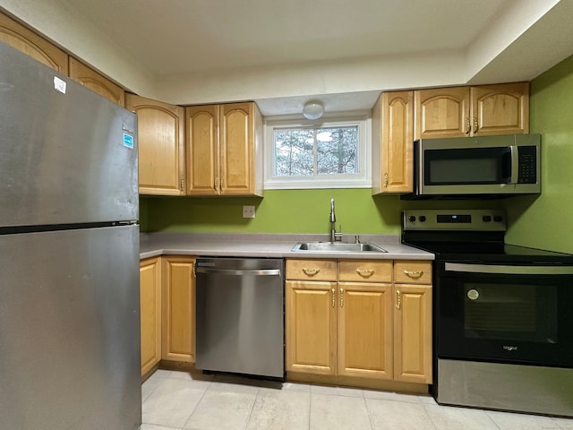 kitchen featuring appliances with stainless steel finishes, light countertops, a sink, and light tile patterned floors