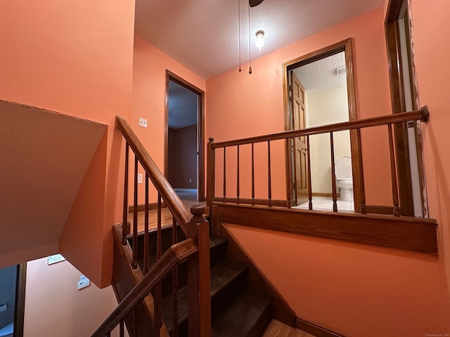 staircase featuring a textured ceiling