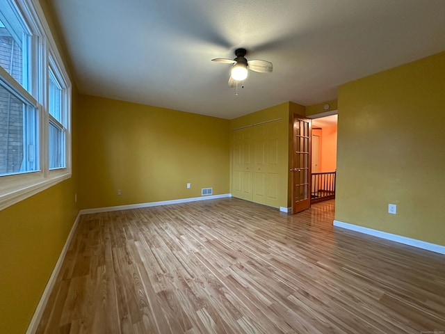 interior space featuring baseboards, visible vents, ceiling fan, wood finished floors, and a closet