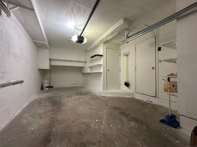 garage with concrete block wall and a garage door opener