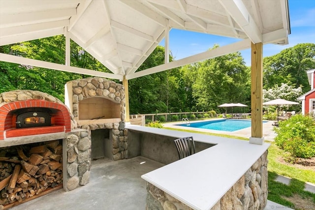view of patio / terrace featuring a fireplace and an outdoor pool