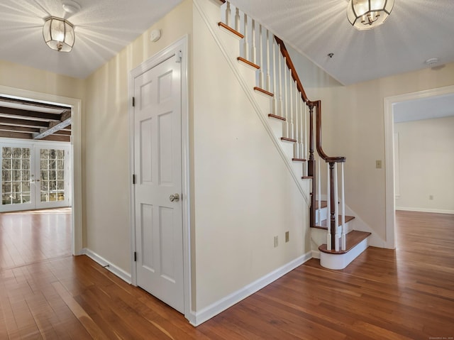 stairs featuring hardwood / wood-style floors and baseboards