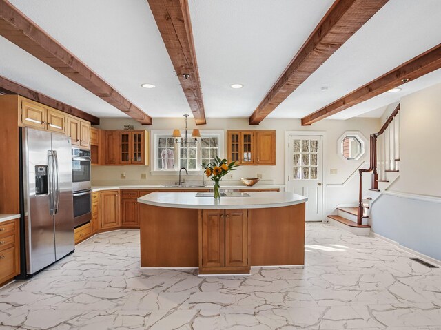 kitchen featuring a kitchen island, light countertops, glass insert cabinets, appliances with stainless steel finishes, and marble finish floor