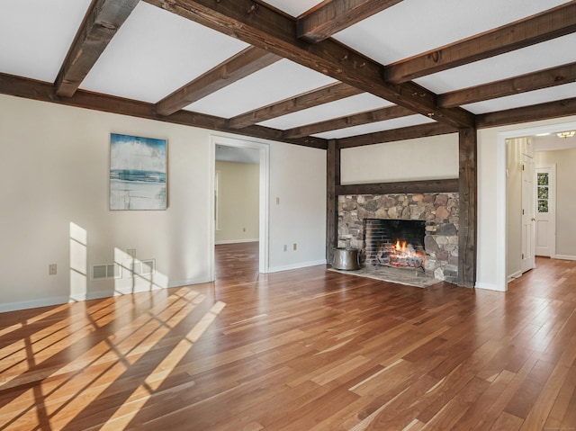 unfurnished living room with beamed ceiling, a fireplace, baseboards, and wood-type flooring