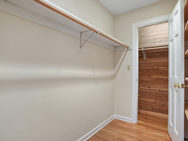 walk in closet with light wood-style floors