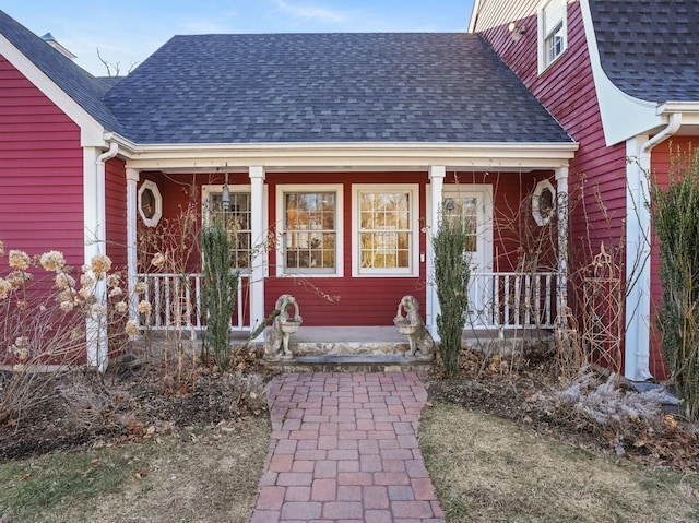property entrance with a shingled roof and covered porch