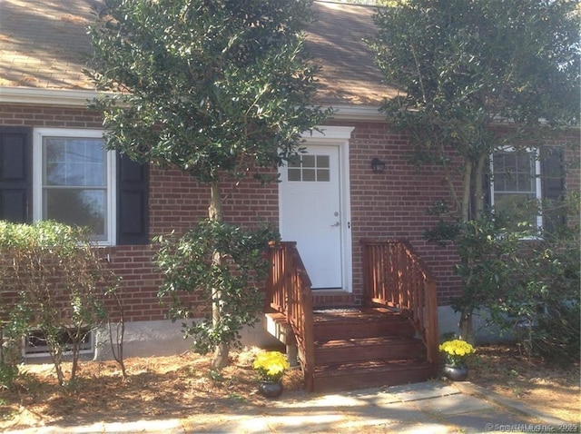 entrance to property featuring brick siding