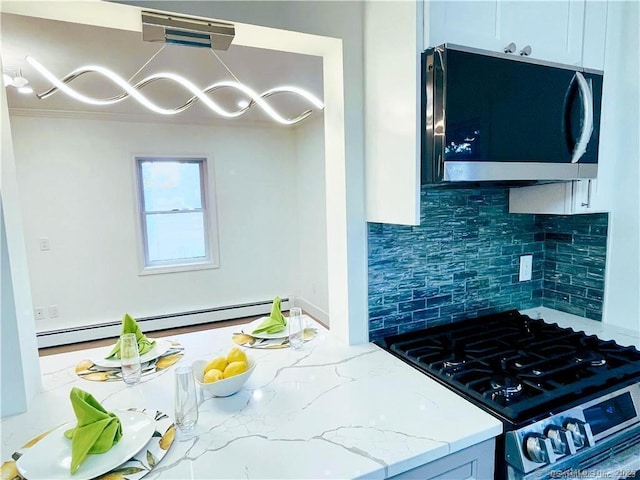 kitchen with baseboard heating, appliances with stainless steel finishes, light stone countertops, decorative backsplash, and white cabinets