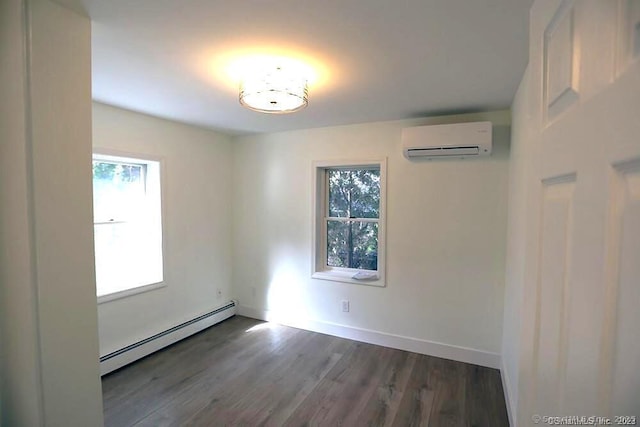 interior space with multiple windows, an AC wall unit, a baseboard heating unit, and dark hardwood / wood-style flooring