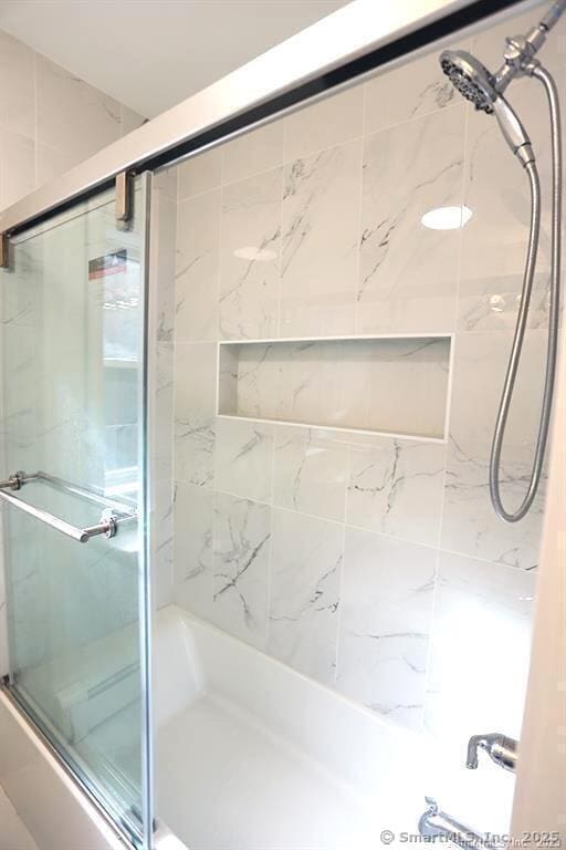 bathroom with shower / bath combination with glass door