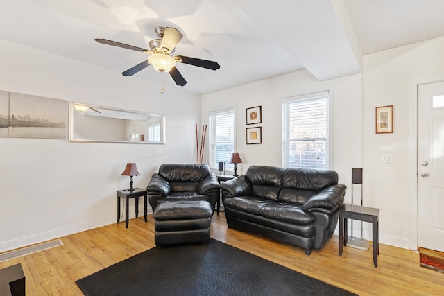 living area featuring a ceiling fan, baseboards, and wood finished floors