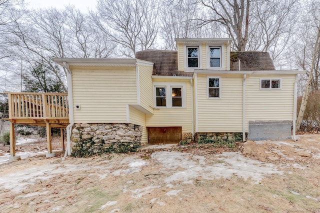 view of property exterior featuring a shingled roof and a wooden deck