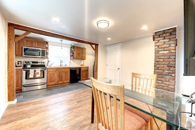 kitchen with stainless steel appliances, a sink, brown cabinets, open shelves, and light wood finished floors