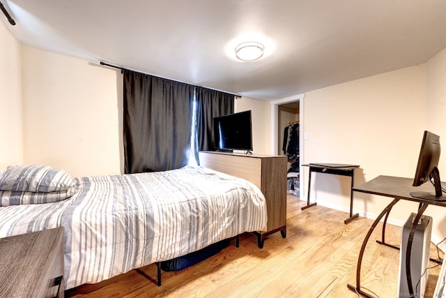 bedroom featuring light wood-style floors and baseboards