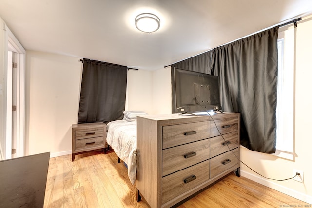 bedroom with light wood-type flooring and baseboards