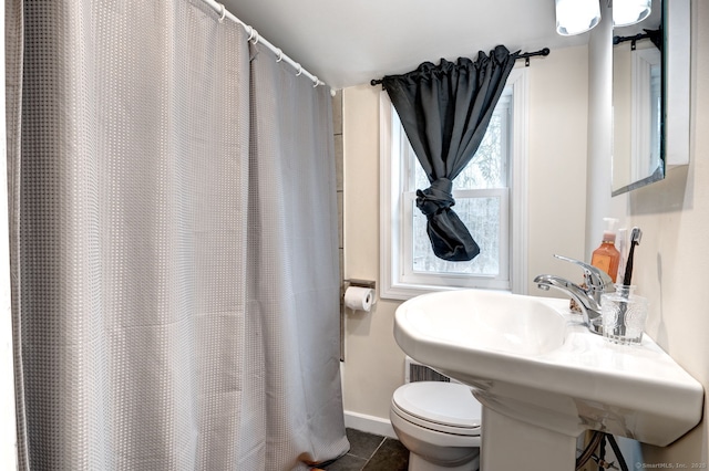 full bath with tile patterned flooring, baseboards, a sink, and toilet