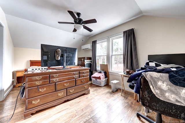 bedroom featuring a wall unit AC, light wood finished floors, baseboards, and vaulted ceiling