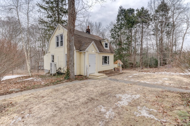 view of front of home featuring roof with shingles, a chimney, and a gambrel roof