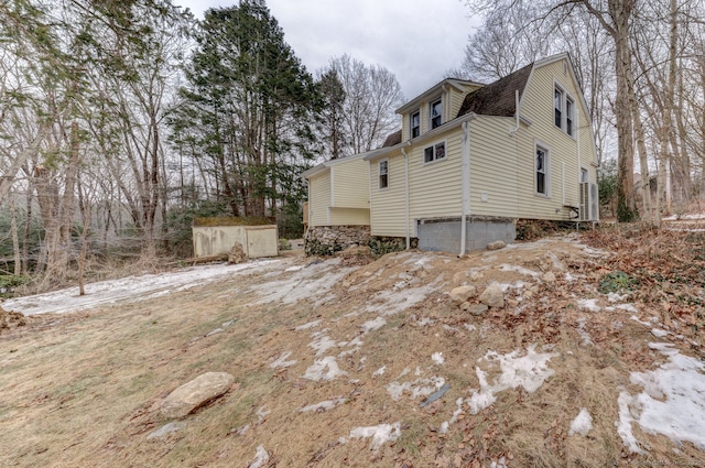 view of side of property featuring roof with shingles and a gambrel roof