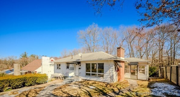 view of front of house with a chimney and fence