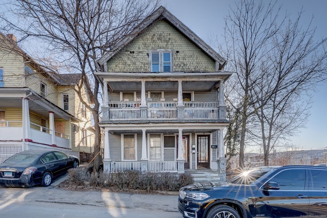 victorian home featuring covered porch and a balcony