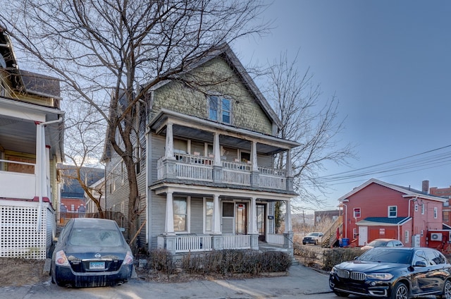 view of property featuring covered porch and a balcony