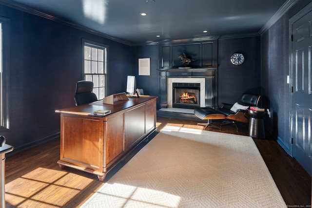 office space with a warm lit fireplace, recessed lighting, dark wood-type flooring, baseboards, and ornamental molding