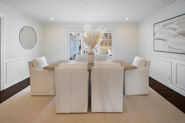 dining area featuring ornamental molding, wainscoting, and wood finished floors