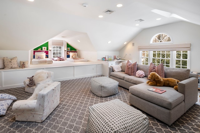 living area with carpet floors, lofted ceiling with skylight, and visible vents