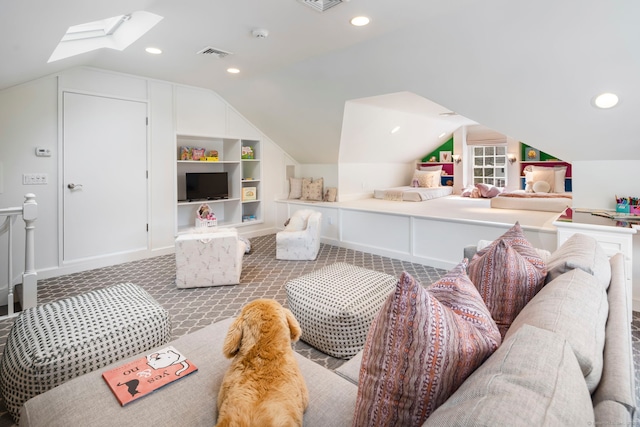 interior space with vaulted ceiling with skylight, carpet floors, visible vents, and built in features