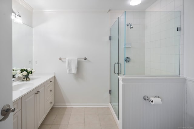 bathroom with a stall shower, baseboards, tile patterned floors, crown molding, and vanity