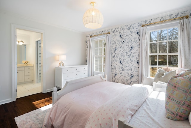 bedroom featuring ensuite bath, baseboards, ornamental molding, and wood finished floors