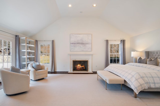 bedroom featuring a warm lit fireplace, high vaulted ceiling, baseboards, and recessed lighting