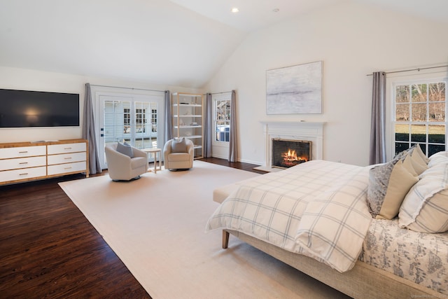 bedroom with a lit fireplace, high vaulted ceiling, wood finished floors, and recessed lighting