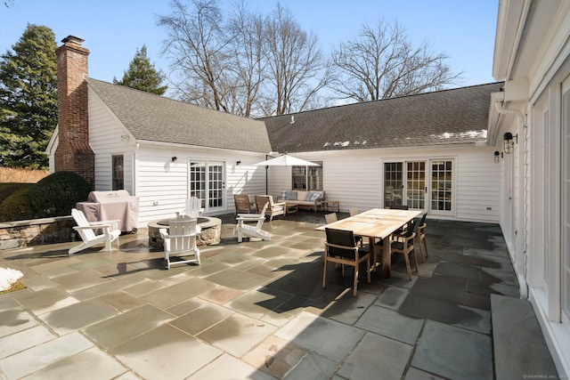 view of patio / terrace with french doors, outdoor dining area, an outdoor living space with a fire pit, and a grill