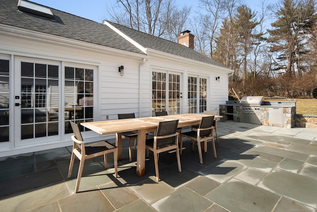 view of patio / terrace featuring french doors, outdoor dining area, exterior kitchen, and area for grilling