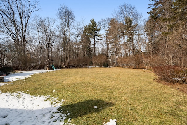 snowy yard featuring a playground