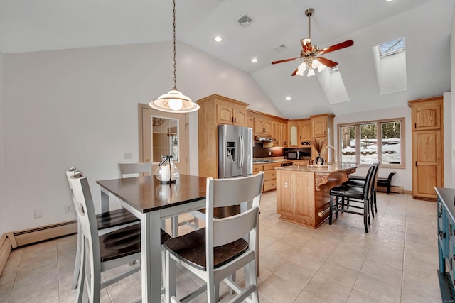 kitchen featuring visible vents, stainless steel fridge with ice dispenser, a center island, lofted ceiling with skylight, and decorative light fixtures