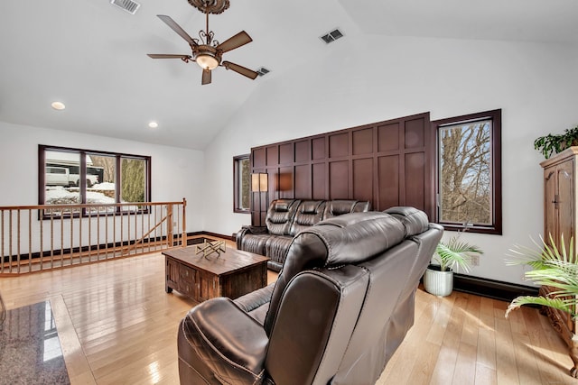 living room featuring high vaulted ceiling, visible vents, ceiling fan, and light wood-style flooring