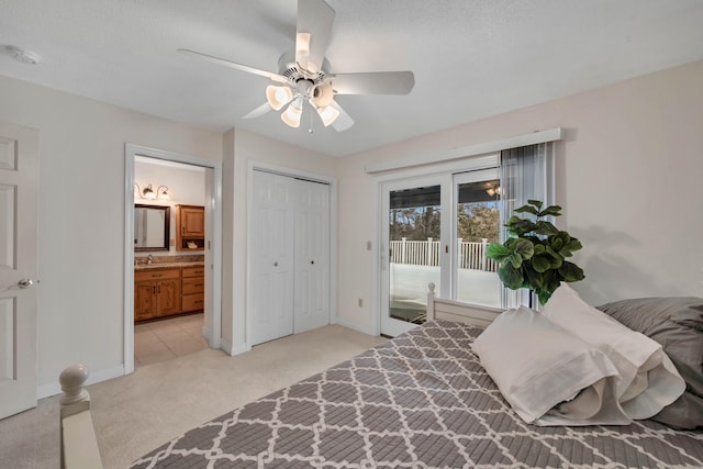 bedroom with access to exterior, light colored carpet, a ceiling fan, ensuite bath, and baseboards