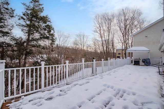 yard layered in snow with fence and a jacuzzi