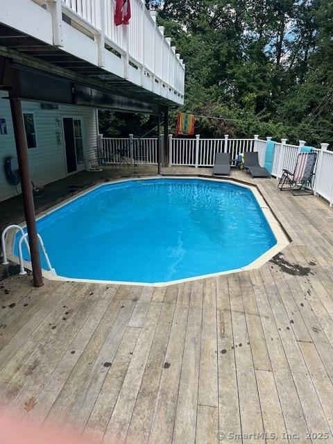 view of swimming pool featuring a deck and a fenced in pool