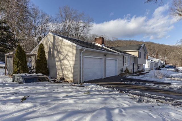 view of snowy exterior with a garage